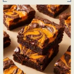Square slices of chocolate brownie topped with creamy cheesecake swirls, garnished with orange sprinkles and small Halloween themed candies.