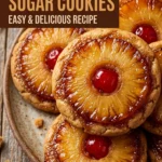 Soft sugar cookies topped with a caramelized pineapple ring and a bright red maraschino cherry in the center.